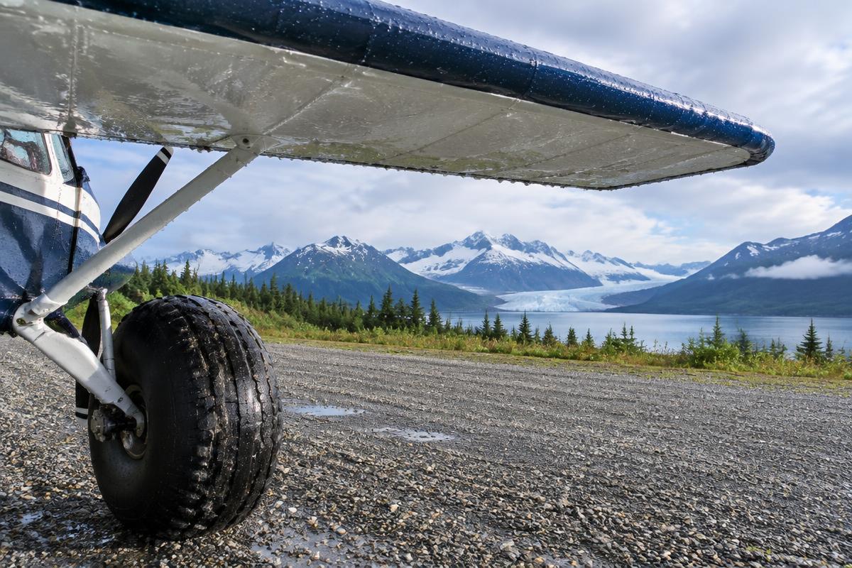 Bush plane wing and tundra tire on a gravel strip